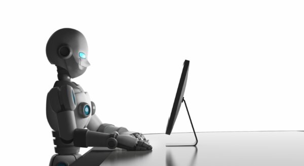 An image of a humanoid robot using a mac as illustration for post 'AI Safety Summit '.