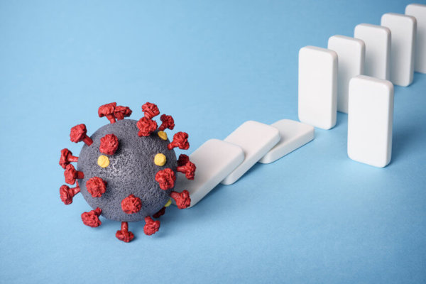 Image of Coronavirus molecule and falling dominoes as illustration for blog post 'the current landscape and its impact'.