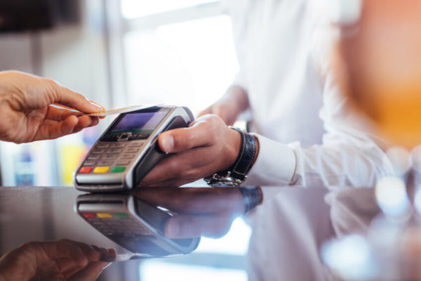 Image of customer paying bill using card and contactless terminal as illustration for blog post 'Contactless Limit to increase to £100'.