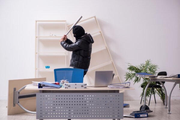 Image of a masked burglar ransacking an office as illustration for post 'Follow your company for peace of mind.'