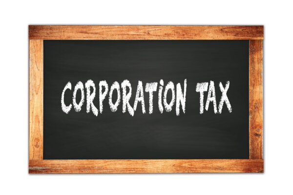 Image of a blackboard with Corporation Tax written on it, as illustration for post 'HMRC Holds £11.9bn in Overpaid Corporation Tax'.