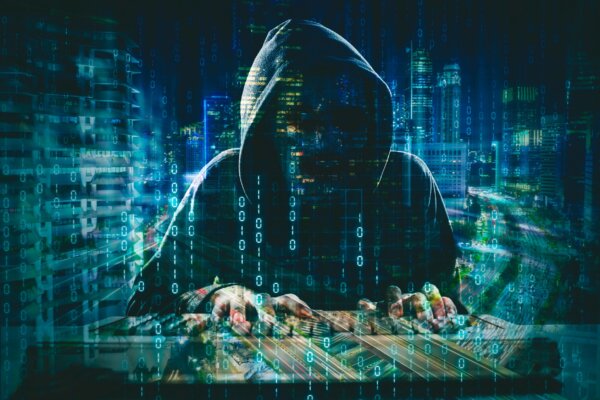 Image of a stereotypical movie-style 'hacker' in a hoody surrounded by data imagery as illustration for post 'New Online tools to improve Cyber Security'