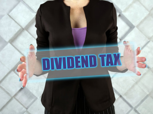 Image of a person holding a sign saying 'Dividend Tax' as illustration for post 'Dividend Tax Rises Effective 6th April 2022'