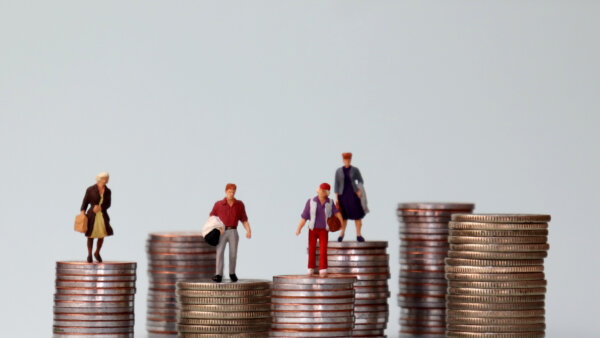 An image of small figurines on top of piles of coins of varying heights as illustration for post 'Changes to National Minimum Wage recommendation criteria'