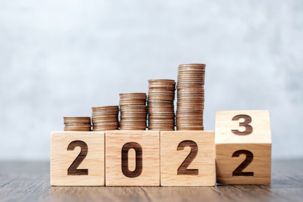 Image of wooden block with stacks of coins above as illustration for post 'Corporation Tax in 2023'.