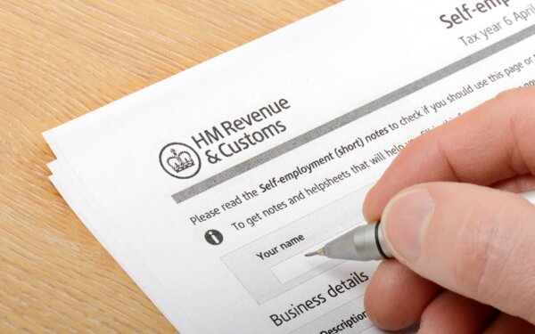 Image of a hand filling in a Paper Tax Return form as illustration for Post 'The end of the paper Tax Return is nigh!'