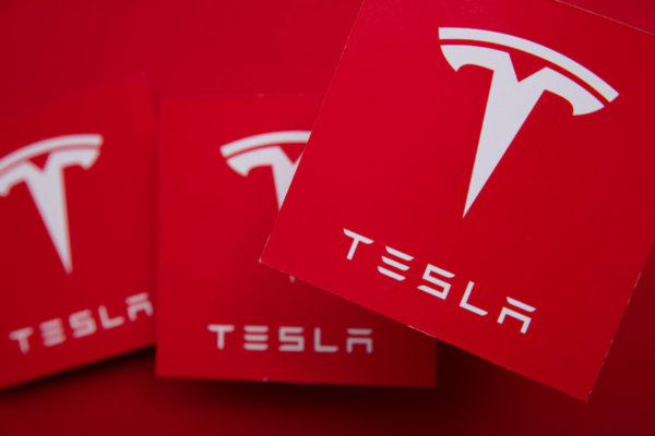 Multiple copies of the Tesla logo as illustration for Post 'How does Company Car Tax Work?'